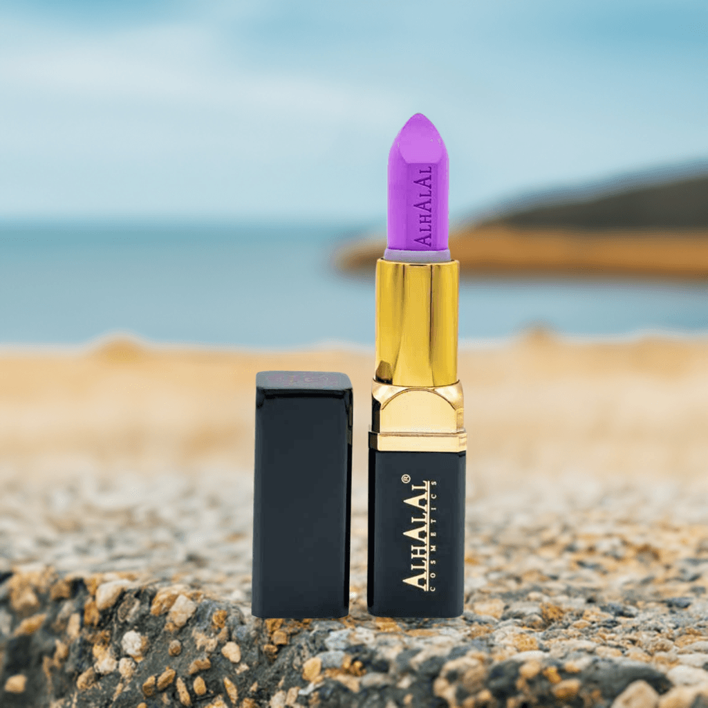 Alhalal cosmetics PARSE LIPPENSTIFT in een paarse fluwelen lipstick met gouden houder op een rotsachtige ondergrond